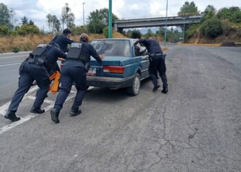 Agentes de la Guardia del Camino inspeccionan un vehículo en la vía.