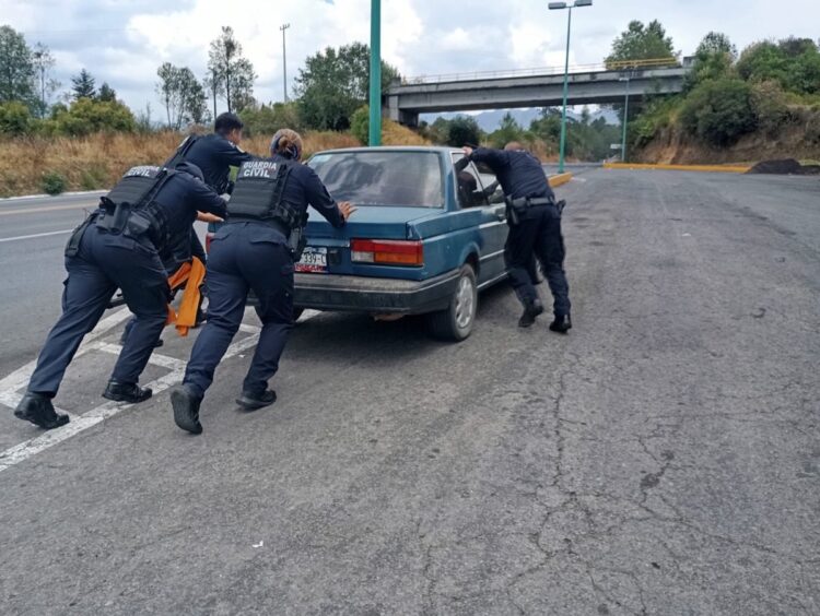 Agentes de la Guardia del Camino inspeccionan un vehículo en la vía.