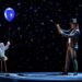 Bajo un cielo estrellado, un niño con globos y un mago en un escenario crean un espectáculo mágico para promover actividades.