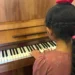Niña tocando el piano en un evento cultural en Michoacán, promoviendo la música y las bandas comunitarias en la región.