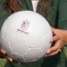 Persona sosteniendo un balón de fútbol con logotipo de Michoacán.