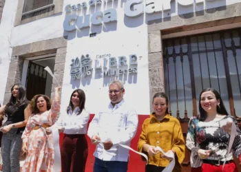 Grupo de mujeres y un hombre en la inauguración del Centro Libre de Mujeres en Michoacán, con sonrisas y documentos en mano.