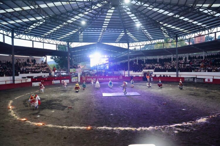 Policías y bomberos participan en un evento en un circo con público en las gradas.