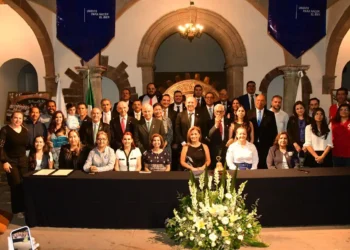 Grupo de políticos y funcionarios en una reunión formal en un edificio histórico.