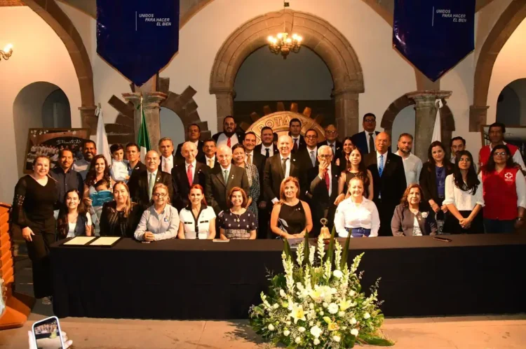 Grupo de políticos y funcionarios en una reunión formal en un edificio histórico.