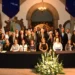 Grupo de políticos y funcionarios en una reunión formal en un edificio histórico.