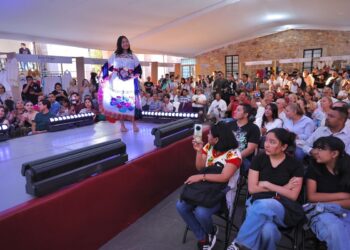 Colorido desfile de artesanos michoacanos en Clavijero, exhibiendo sus creaciones tradicionales en un evento cultural vibrant.