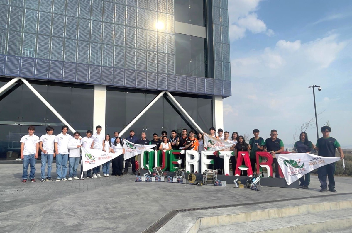 Estudiantes y docentes muestran su talento en robótica frente a un edificio moderno.