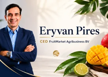 Eryvan Pires, CEO de FruitMarket Agribusiness BV, en una imagen profesional con fondo de frutas tropicales y vegetales fresco.
