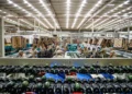 Trabajadores en línea de producción de botellas de cerveza en una fábrica moderna en México.