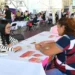 Mujer en feria de empleo en Michoacán conversando con una representante.