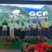 Grupo de personas en una conferencia con fondo digital de naturaleza y logo de GCF.