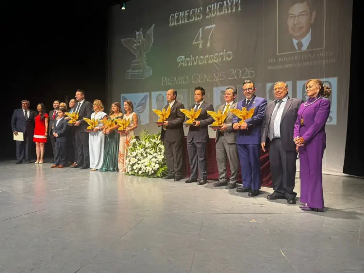 Personas en el escenario durante la ceremonia del Premio Génesis 2026, con un fondo que conmemora el 47 aniversario y el prem.