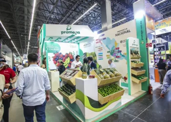 Stand de Promega en feria agrícola con productos frescos y exhibiciones regionales.