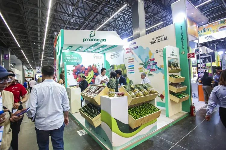 Stand de Promega en feria agrícola con productos frescos y exhibiciones regionales.