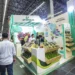 Stand de Promega en feria agrícola con productos frescos y exhibiciones regionales.