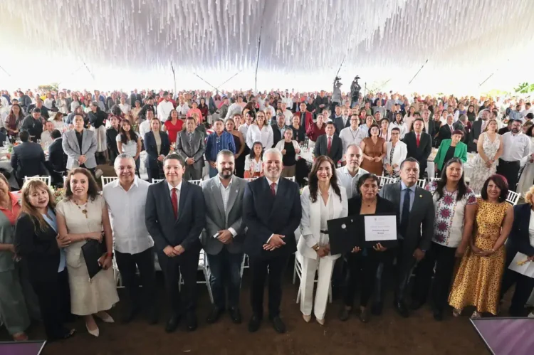 Personas en evento formal con reconocimiento y certificado en un espacio decorado con techumbre blanca.