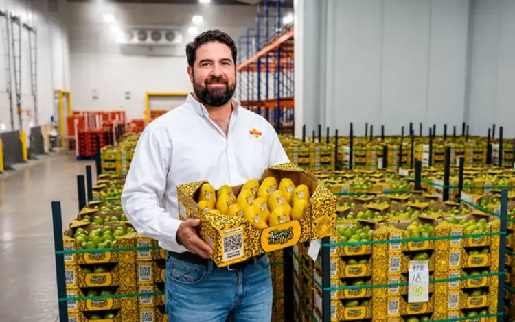 Fábrica de productos agrícolas en Jalisco, México, con un hombre sosteniendo una caja de frutas y verduras frescas en un alma.
