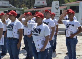 Jóvenes en uniforme y con gorra roja participan en ceremonia de graduación del Servicio Militar en Zamora.