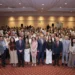 Grupo diverso de personas en evento formal en un salón de conferencias.