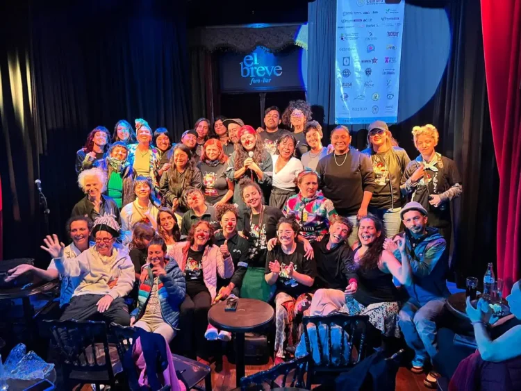 Grupo de personas en el escenario de El Breve, participando en un evento con risas y alegría.