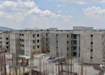 Edificios en construcción en Michoacán, con estructura de concreto y maquinaria en obra.