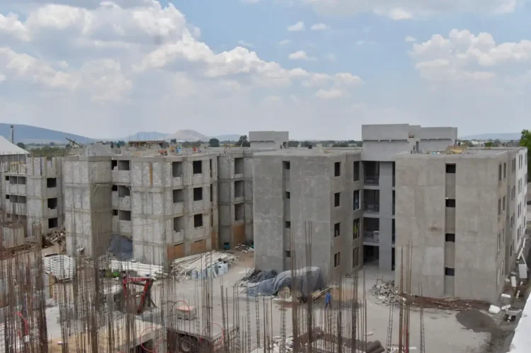 Edificios en construcción en Michoacán, con estructura de concreto y maquinaria en obra.