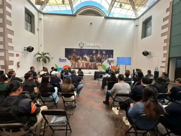 Audiencia en Zamora durante capacitación en ética pública con asistentes sentados en sillas y pantalla digital.