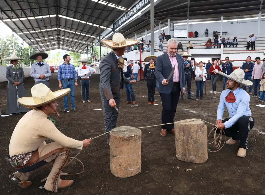 Personas participando en una competencia tradicional de tiro con cuerda en un evento cultural en Michoacán, con espectadores.