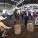 Personas participando en una competencia tradicional de tiro con cuerda en un evento cultural en Michoacán, con espectadores.