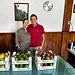 Pareja sonriendo con cajas de frutas en un establecimiento.