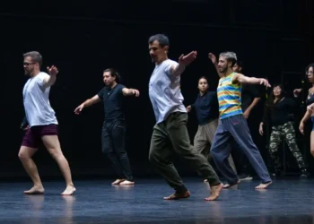 Grupo de bailarines en escenario durante ensayo de danza contemporánea en Michoacán.