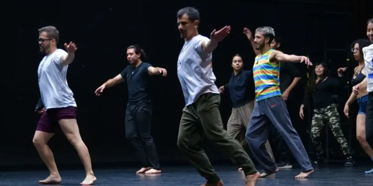 Grupo de bailarines en escenario durante ensayo de danza contemporánea en Michoacán.