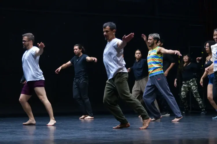 Grupo de bailarines en escenario durante ensayo de danza contemporánea en Michoacán.