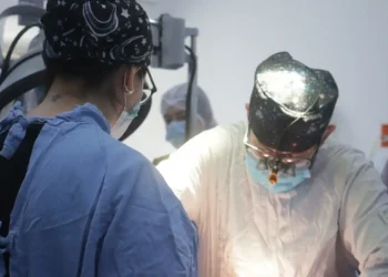 Personal médico realizando una cirugía en un entorno hospitalario.