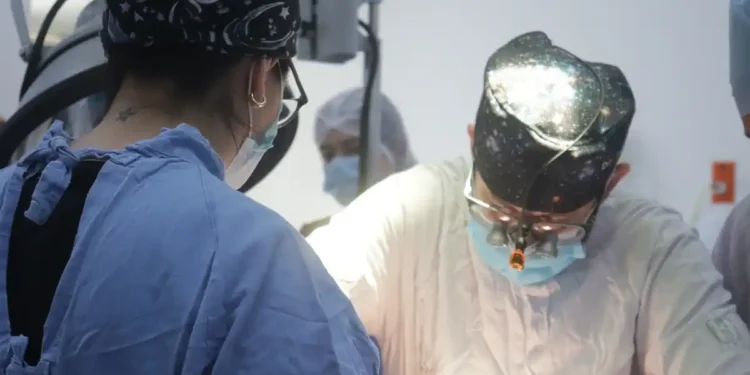 Personal médico realizando una cirugía en un entorno hospitalario.