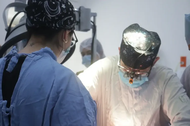 Personal médico realizando una cirugía en un entorno hospitalario.