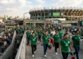 Aficionados con camisetas verdes ingresan al Estadio Azteca para apoyar a la selección mexicana.