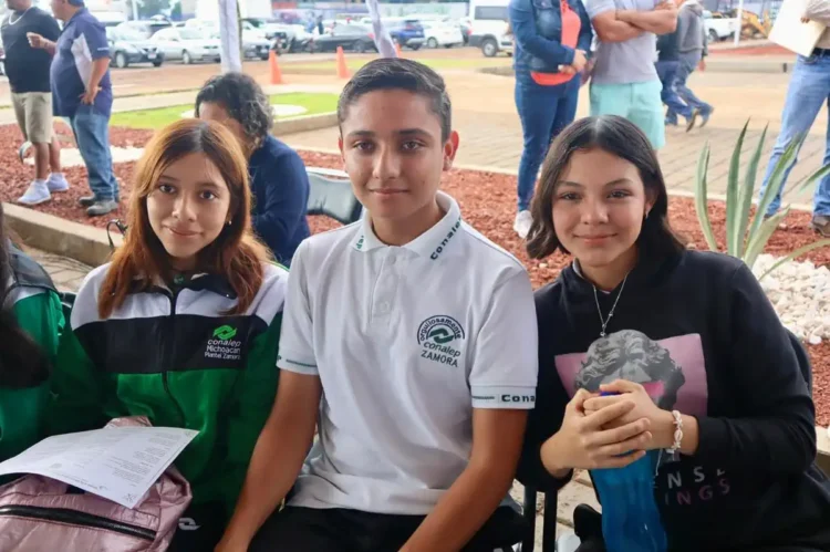 Jóvenes en una actividad escolar en Michoacán, participando en un evento al aire libre con otros estudiantes y docentes en un.