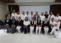 Grupo de profesionales de la salud en capacitación en Zamora, Michoacán, con fondo de pantalla y bandera mexicana.
