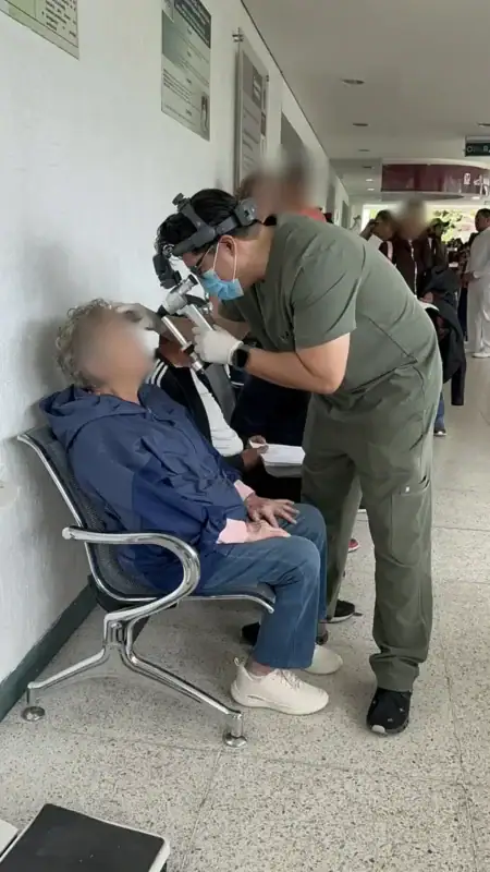 Médico del IMSS atendiendo a una paciente en consulta visual en un hospital de Michoacán.
