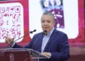 Hombre en conferencia presenta un sistema de pago digital mediante código QR, promoviendo la innovación en transacciones en M.