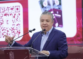 Hombre en conferencia presenta un sistema de pago digital mediante código QR, promoviendo la innovación en transacciones en M.