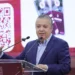 Hombre en conferencia presenta un sistema de pago digital mediante código QR, promoviendo la innovación en transacciones en M.
