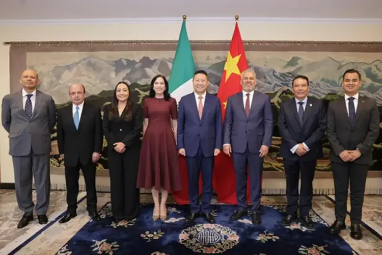Funcionarios de China y México posan juntos en reunión oficial con banderas de ambos países.