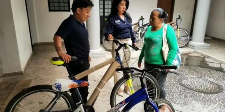 Personas conversando junto a bicicletas en un espacio cubierto.