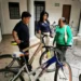 Personas conversando junto a bicicletas en un espacio cubierto.