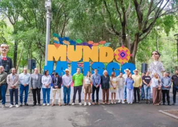 Personas participando en evento cultural en Michoacán, frente a letras grandes y coloridas que dicen "MUNDO".