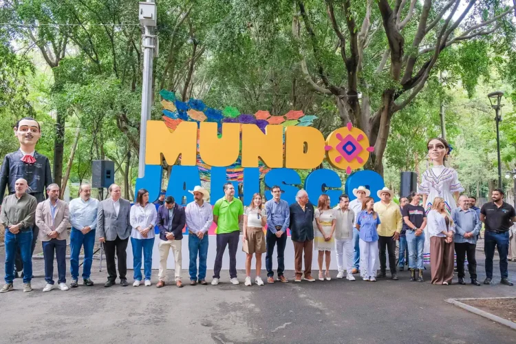 Personas participando en evento cultural en Michoacán, frente a letras grandes y coloridas que dicen "MUNDO".