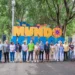 Personas participando en evento cultural en Michoacán, frente a letras grandes y coloridas que dicen "MUNDO".
